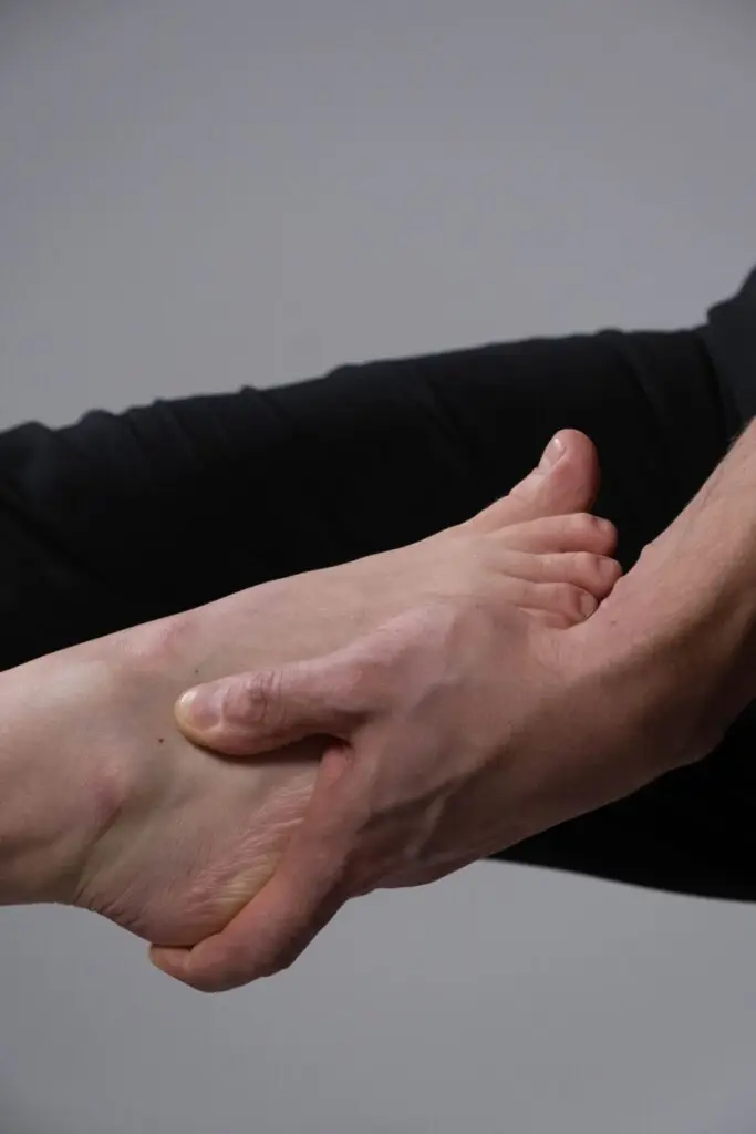 Close-up of a hand supporting a foot, symbolizing care and connection.