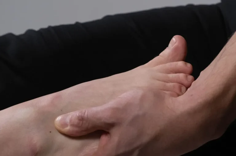 Close-up of a hand supporting a foot, symbolizing care and connection.